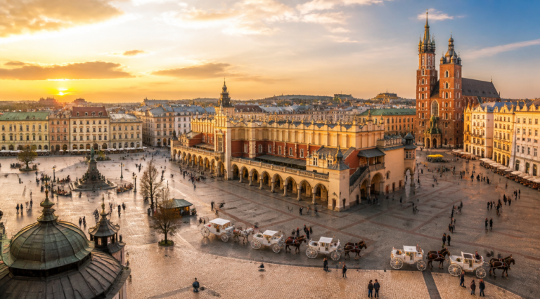 Stunning panoramic view of Krakow's Main Market Square (Rynek Gł&oacute;wny) in Poland during golden hour, with the iconic Cloth Hall (Sukiennice) in the center, surrounded by colorful historic townhouses with ornate facades, horse-drawn carriages, tourists walking across the cobblestone square, and St. Mary's Basilica twin towers visible in the background, warm sunset light casting long shadows, photorealistic travel photography style, high detail, vibrant colors, 16:9 aspect ratio, professional composition